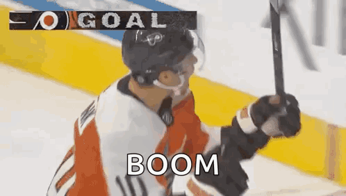 A Hockey Player Is Holding A Hockey Stick In The Air While Celebrating A Goal . GIF