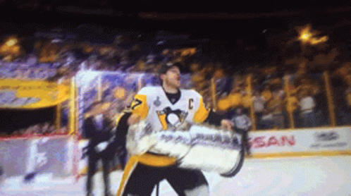 A Hockey Player Is Holding A Trophy In Front Of A Nissan Sign GIF