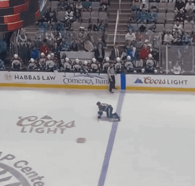 A Hockey Player Is Kneeling On The Ice In Front Of A Coors Light Advertisement GIF