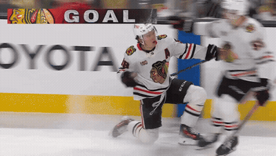 A Hockey Player Is Kneeling On The Ice In Front Of A Goal Banner GIF