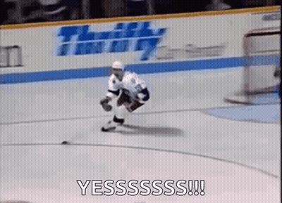A Hockey Player Is Skating On The Ice With A Puck In His Hands . GIF