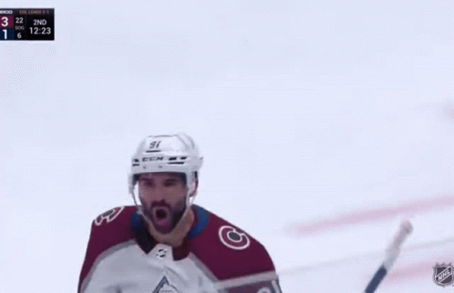 A Hockey Player Is Standing On The Ice With A Hockey Stick In His Hand . GIF