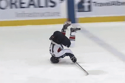 A Hockey Player Is Upside Down On The Ice In Front Of An Advertisement For Oreal GIF