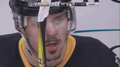 A Hockey Player Is Wearing A Helmet And Holding A Hockey Stick GIF