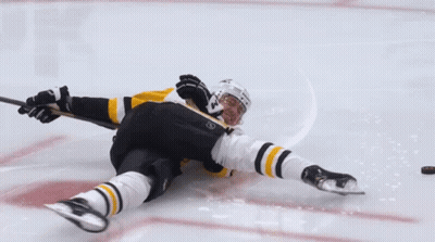 A Hockey Player Laying On The Ice With A Stick GIF