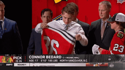 A Hockey Player Named Connor Bedard Is Being Presented With His Jersey GIF