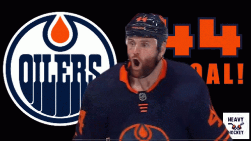 A Hockey Player Stands In Front Of A Logo For The Oilers GIF
