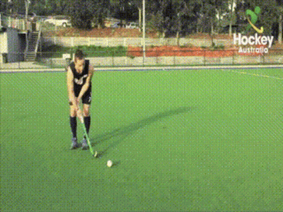 A Hockey Player Stands On A Field With A Sign That Says Hockey Australia GIF