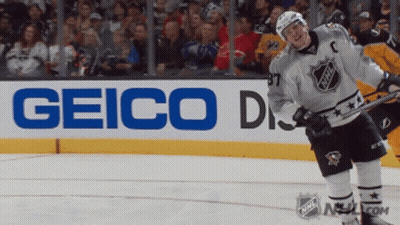 A Hockey Player Stands On The Ice In Front Of A Sign For Geico GIF