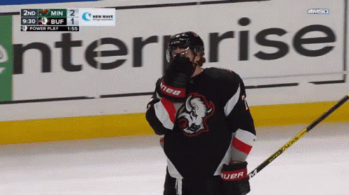 A Hockey Player Stands On The Ice In Front Of An Enterprise Banner GIF