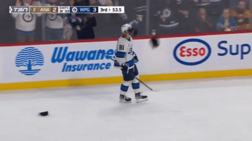 A Hockey Player Stands On The Ice In Front Of An Esso Sign GIF