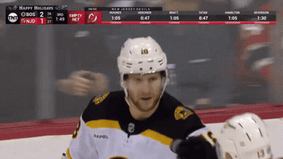 A Hockey Player Stands On The Ice With A Scoreboard Behind Him That Says Happy Holidays GIF