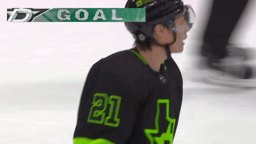 A Hockey Player Wearing A Black And Green Jersey With The Number 21 GIF