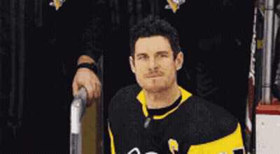 A Hockey Player Wearing A Black And Yellow Jersey With The Number 23 On It GIF