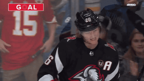 A Hockey Player Wearing A Black Jersey With The Number 6 On It GIF