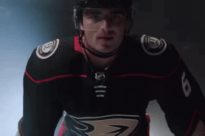 A Hockey Player Wearing A Black Jersey With The Number 8 On The Sleeve GIF