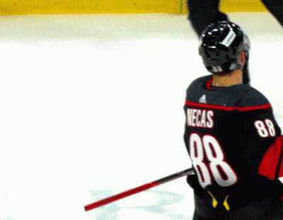 A Hockey Player Wearing A Black Jersey With The Number 88 On The Back GIF
