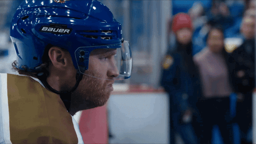 A Hockey Player Wearing A Blue Helmet With Bauer On It GIF