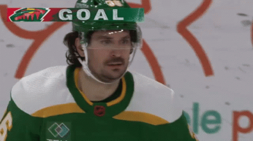 A Hockey Player Wearing A Green And White Jersey With The Word Goal Above Him GIF