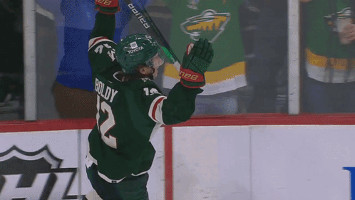 A Hockey Player Wearing A Green Jersey With Boldy On The Back GIF