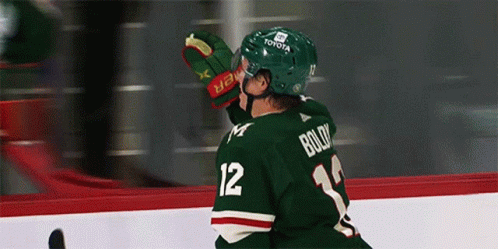 A Hockey Player Wearing A Green Jersey With Boldy On The Back GIF