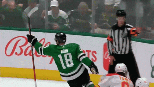 A Hockey Player Wearing A Green Jersey With The Number 18 On It GIF