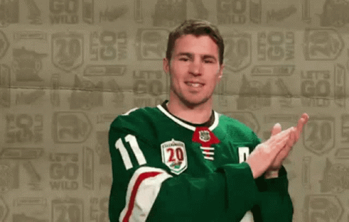 A Hockey Player Wearing A Green Jersey With The Number 20 On It GIF