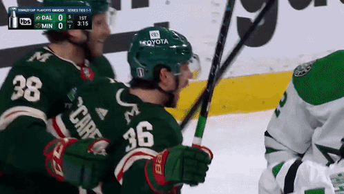 A Hockey Player Wearing A Green Jersey With The Number 36 On The Back GIF