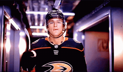 A Hockey Player Wearing A Helmet And A Jersey That Says Ducks Sticking Out His Tongue GIF