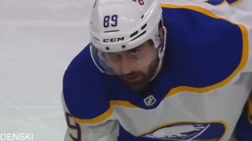 A Hockey Player Wearing A Helmet With The Number 89 On It Is Looking At The Camera . GIF