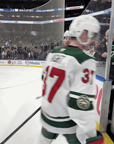 A Hockey Player Wearing A Jersey With The Number 37 On It GIF