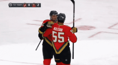 A Hockey Player Wearing A Number 55 Jersey Is Hugging Another Player GIF