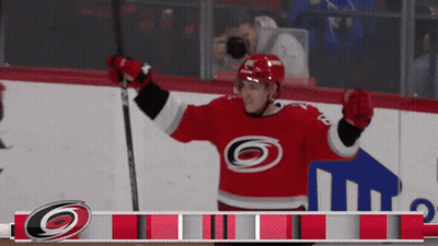 A Hockey Player Wearing A Red Jersey With A Black And White Circle On It GIF