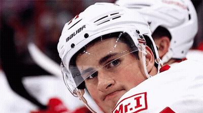 A Hockey Player Wearing A White Bauer Helmet Looks At The Camera GIF