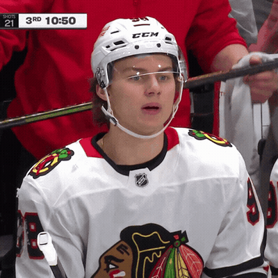A Hockey Player Wearing A White Ccm Helmet Looks At The Camera GIF