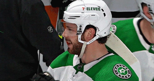 A Hockey Player Wearing A White Helmet With 7 Eleven On It GIF