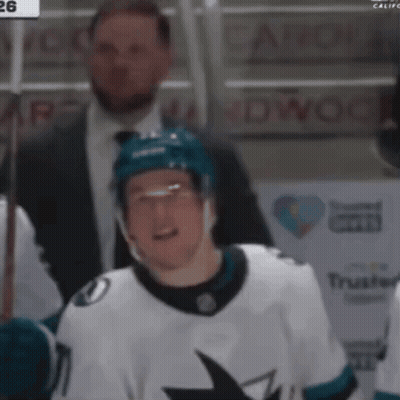 A Hockey Player Wearing A White Jersey With A Shark On The Front GIF