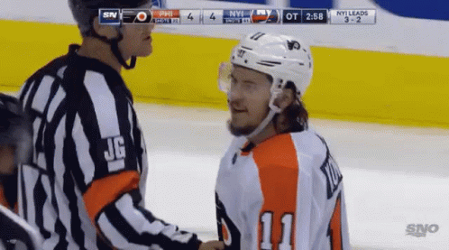 A Hockey Player Wearing Number 11 Shakes Hands With A Referee During A Game GIF