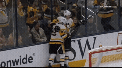 A Hockey Player Wearing Number 59 Hugs Another Player GIF