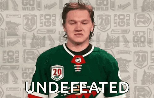 A Hockey Player With His Eyes Closed And The Word " Undefeated " On His Chest GIF