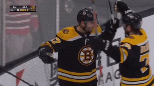A Hockey Player With The Letter B On His Jersey Hugs Another Player GIF
