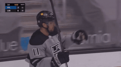 A Hockey Player With The Number 11 On His Jersey Is Holding A Hockey Stick GIF