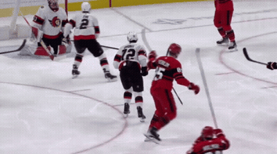 A Hockey Player With The Number 12 On His Jersey Stands On The Ice GIF