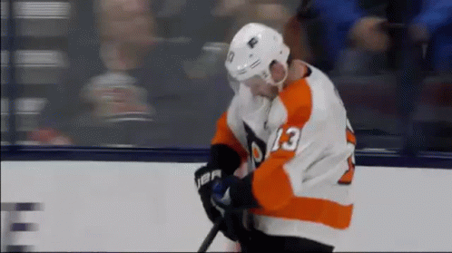 A Hockey Player With The Number 13 On His Jersey Is Holding A Stick . GIF