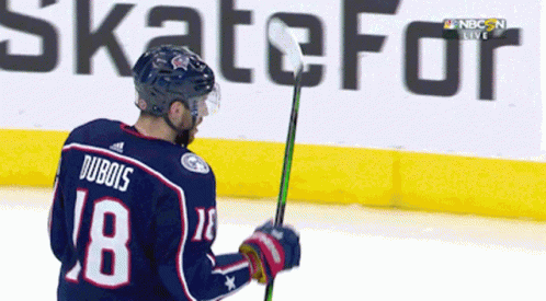 A Hockey Player With The Number 18 On His Jersey Is Holding A Stick GIF