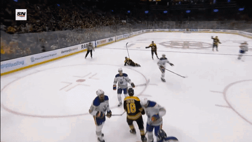 A Hockey Player With The Number 18 On His Jersey Stands On The Ice Surrounded By His Teammates GIF