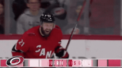 A Hockey Player With The Number 21 On His Jersey Is Holding A Stick GIF