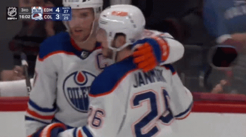 A Hockey Player With The Number 24 On His Jersey Hugging Another Player GIF