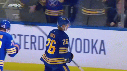 A Hockey Player With The Number 26 On His Back Is Holding A Stick GIF