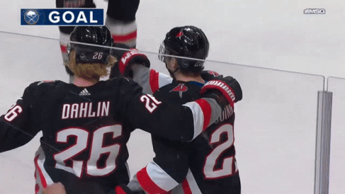 A Hockey Player With The Number 26 On His Back Is Hugging Another Player GIF